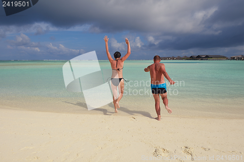 Image of happy young couple have fun on beach