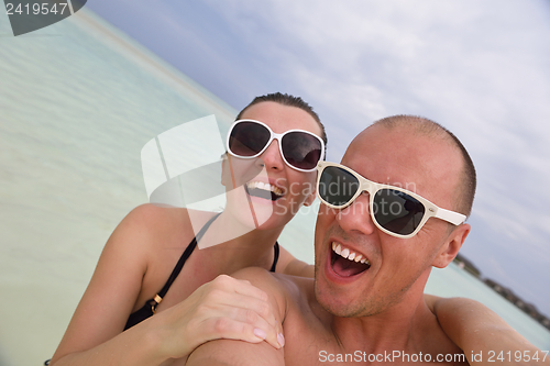 Image of happy young couple have fun on beach