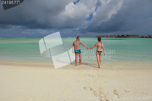 Image of happy young couple have fun on beach