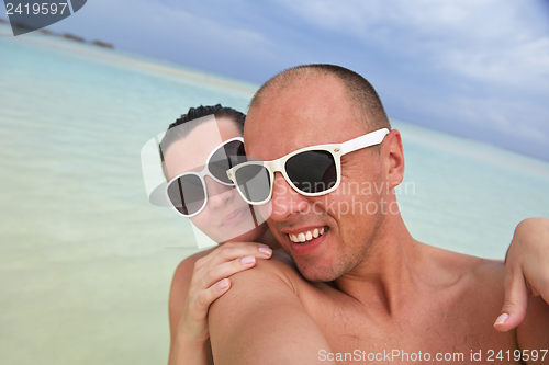 Image of happy young couple have fun on beach