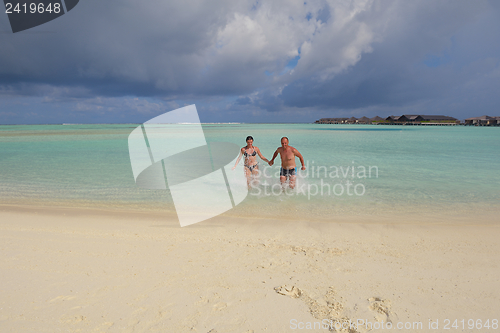 Image of happy young couple have fun on beach