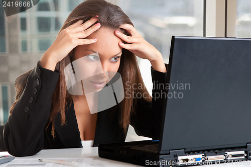 Image of Worried Woman Looking At A Computer Monitor