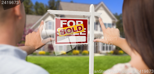 Image of Sold For Sale Sign, House and Military Couple Framing Hands