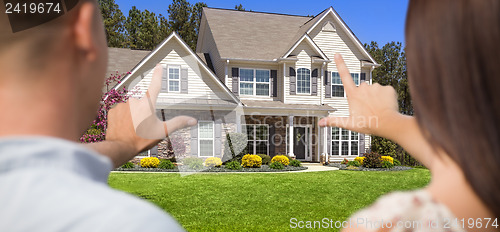 Image of House and Military Couple Framing Hands in Front