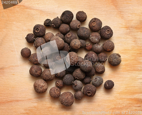 Image of pimento peppercorns macro on wooden board