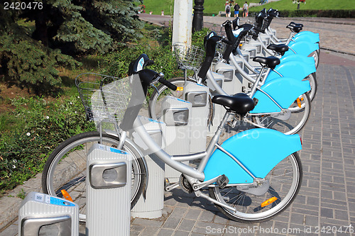 Image of bicycles in row on parking for rental