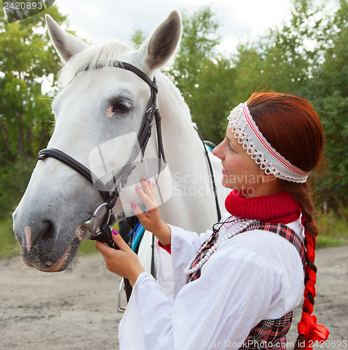 Image of The girl stroking horse