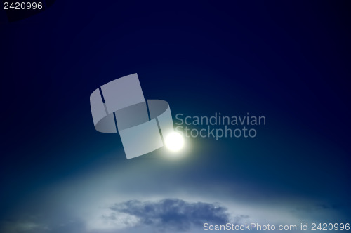 Image of Bright shine through night sky with clouds