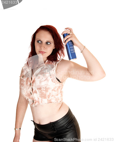 Image of Girl putting hair spray on.