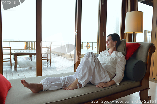 Image of happy young woman relax at home on sofa