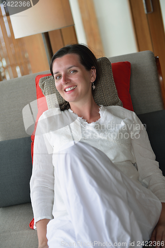 Image of happy young woman relax at home on sofa