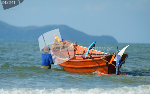 Image of Fisherman taking his boat to sea