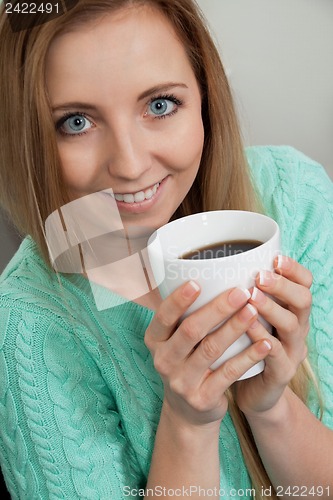 Image of smiling young woman drinking coffee