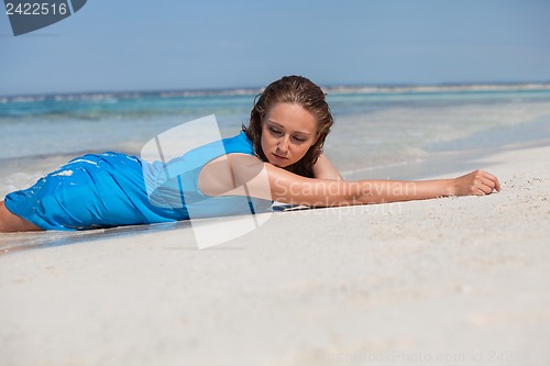 Image of attractive young woman in blue dress on the beach