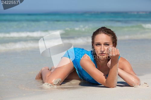 Image of attractive young woman in blue dress on the beach