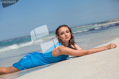Image of attractive young woman in blue dress on the beach