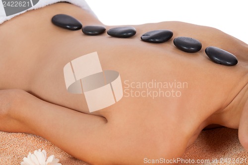 Image of attractive healthy caucasian woman hot stone massage wellness 