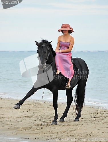 Image of girl and  horse on the beach