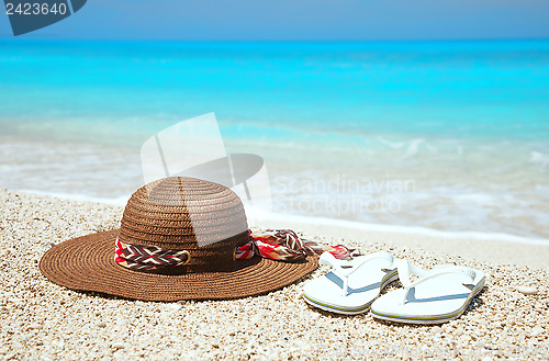 Image of Hat and flip-flops on a beach
