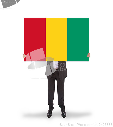 Image of Businessman holding a big card, flag of Guinea