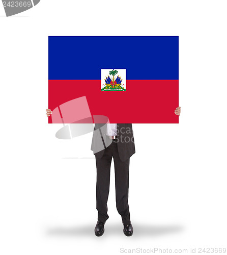 Image of Businessman holding a big card, flag of Haiti