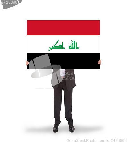 Image of Businessman holding a big card, flag of Iraq