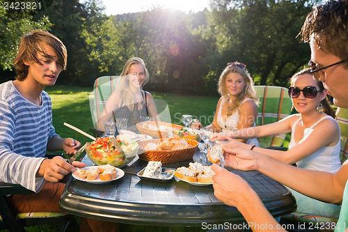 Image of Friends Enjoying Meal At Garden Party