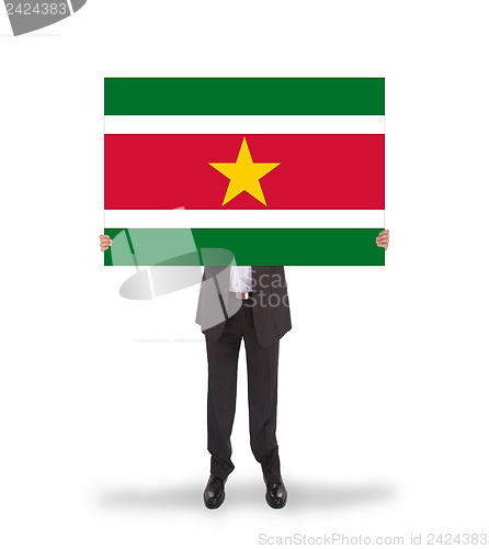 Image of Businessman holding a big card, flag of Suriname