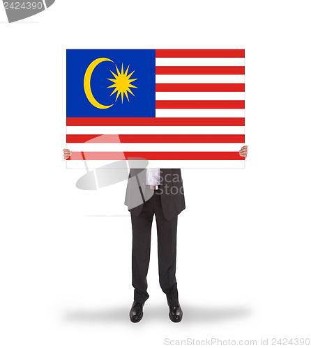 Image of Businessman holding a big card, flag of Malaysia