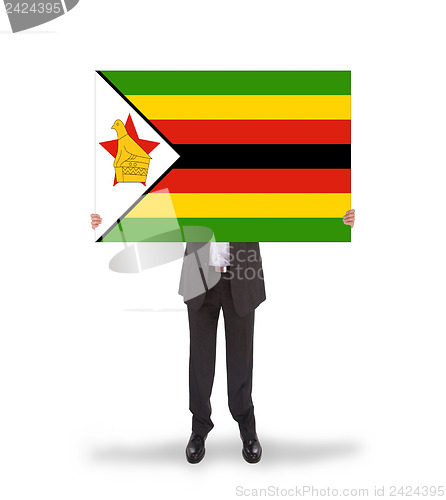 Image of Businessman holding a big card, flag of Zimbabwe