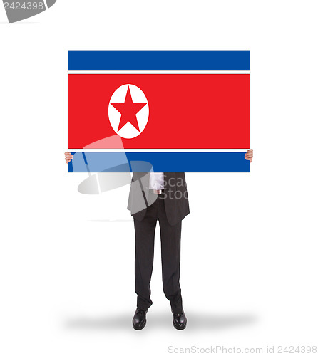 Image of Businessman holding a big card, flag of North Korea