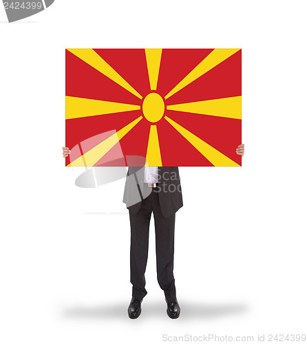 Image of Businessman holding a big card, flag of Macedonia