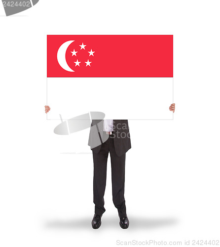Image of Businessman holding a big card, flag of Singapore