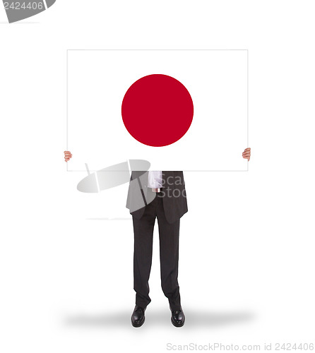 Image of Businessman holding a big card, flag of Japan