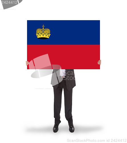 Image of Businessman holding a big card, flag of Liechtenstein