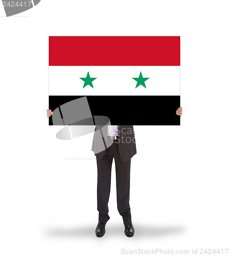 Image of Businessman holding a big card, flag of Syria