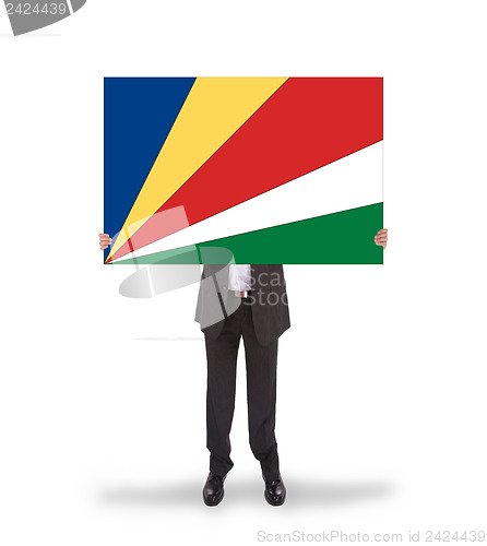 Image of Businessman holding a big card, flag of Seychelles