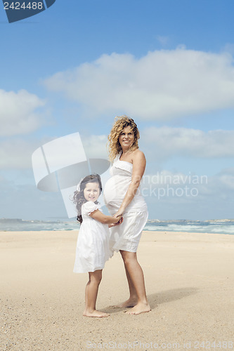 Image of Pregnant woman and her daughter on the beach