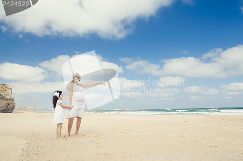 Image of Pregnant woman and her daughter on the beach