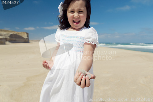 Image of Girl on the beach holding stones