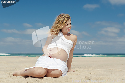 Image of Pregnant woman sitting on the beach