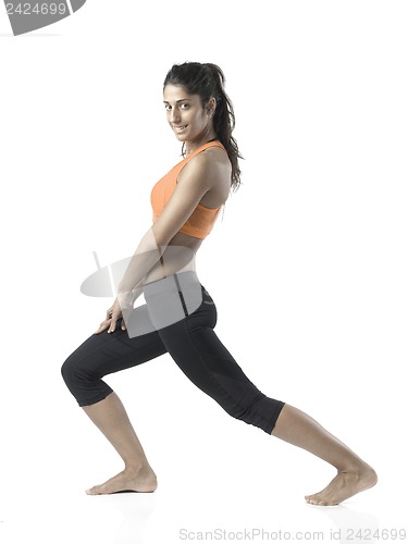 Image of fit woman stretching on white