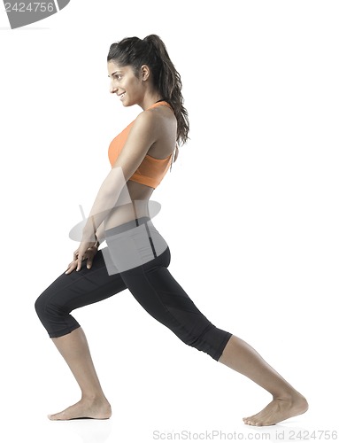 Image of fit woman stretching on white