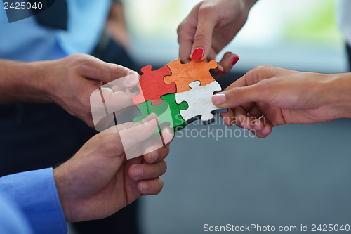 Image of Group of business people assembling jigsaw puzzle