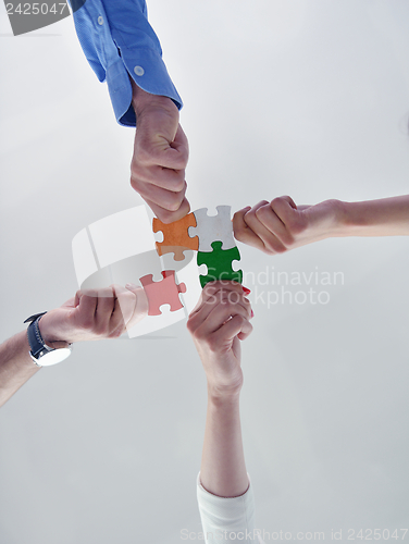 Image of Group of business people assembling jigsaw puzzle