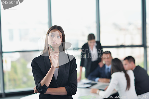 Image of business woman with her staff in background at office