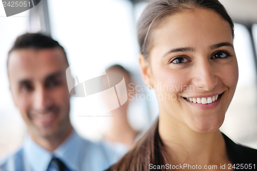 Image of business woman with her staff in background at office