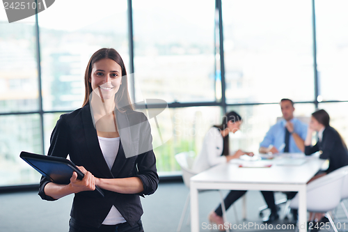 Image of business woman with her staff in background at office