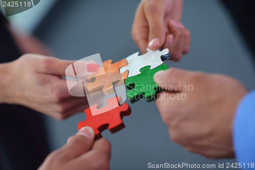 Image of Group of business people assembling jigsaw puzzle