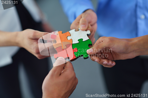 Image of Group of business people assembling jigsaw puzzle